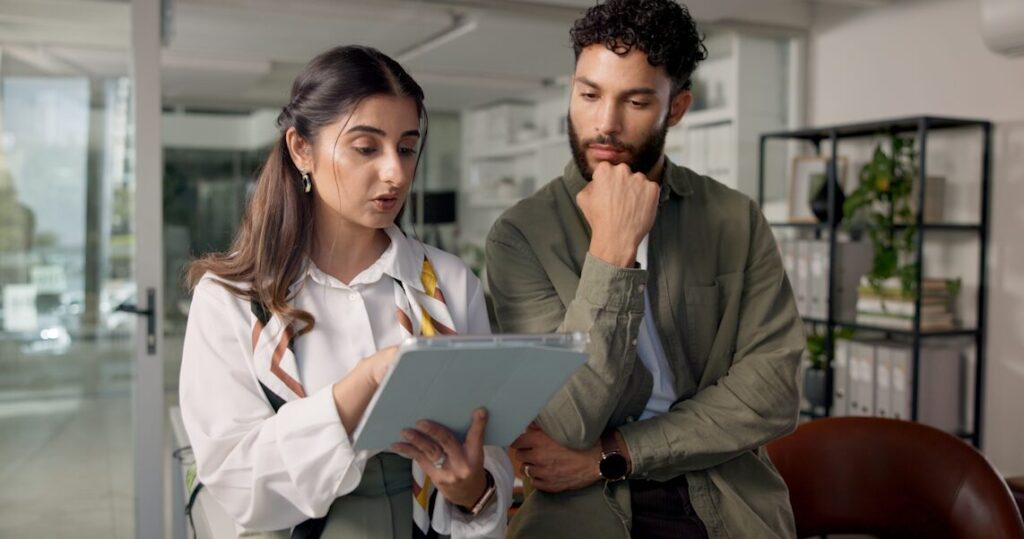 man and woman looking at ipad, discussing what it is on it
